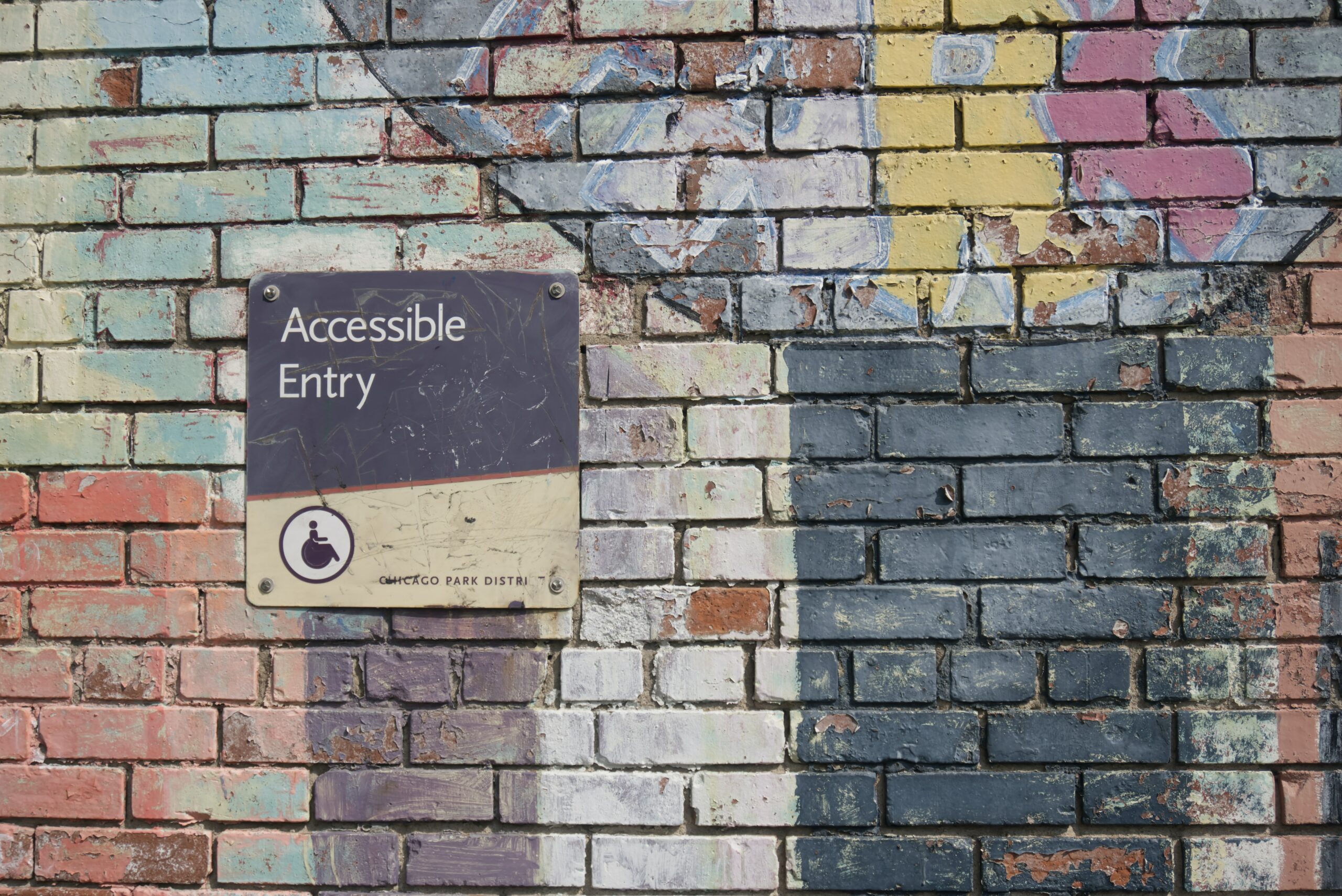 A multi-coloured brink wall sports a sign reading "Accessible Entry," but no door is visible.