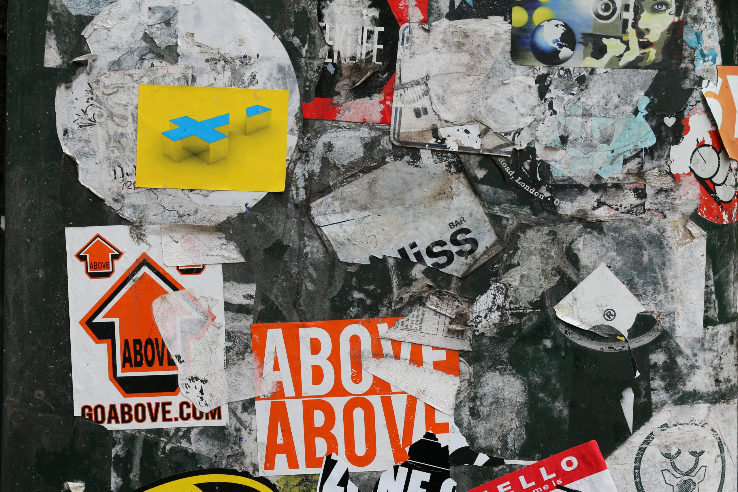 A collage of destroyed posters on the wall of a building.