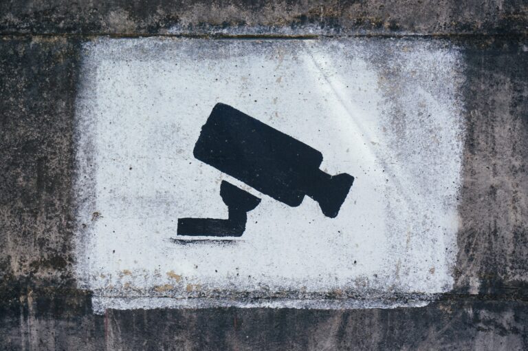 A stencilled camera on a cement wall.